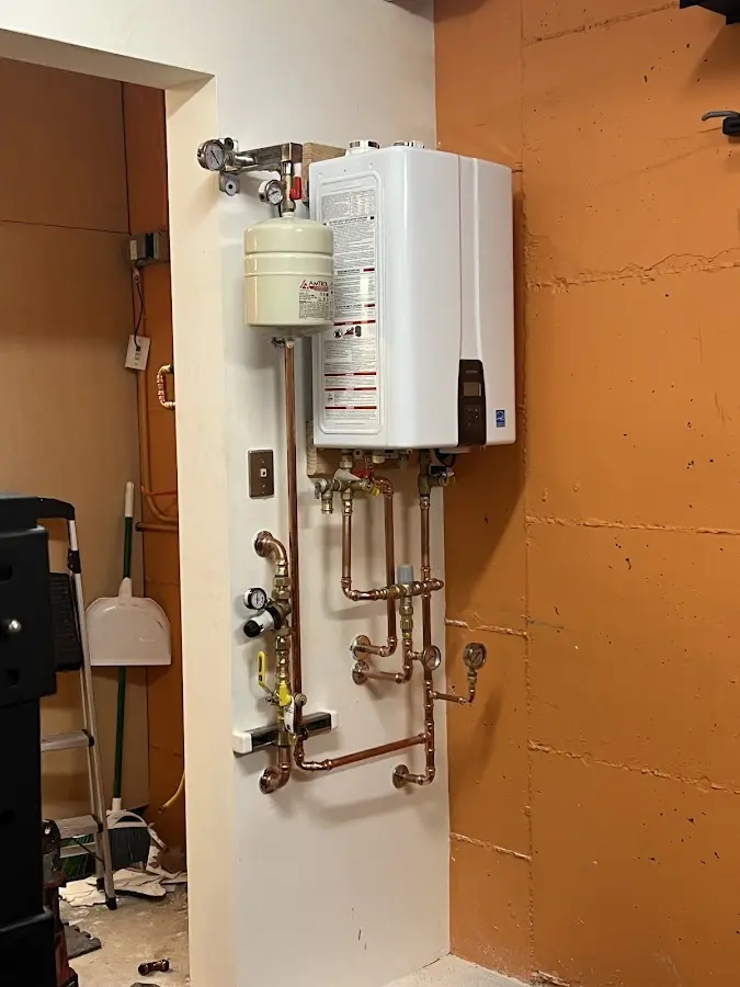 Plumbing technician inspecting water heater connections in Lehigh